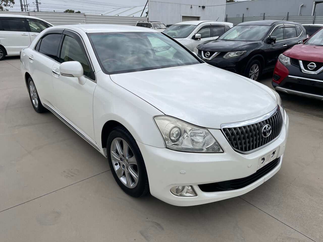 2012 Toyota Crown Majesta V8 4.6L C Type Luxury Sedan in white parked in a lot, showcasing its sleek exterior.