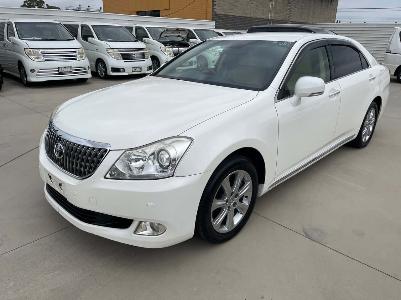 2012 Toyota Crown Majesta V8 4.6L C Type luxury sedan in white, parked with other vehicles in background.