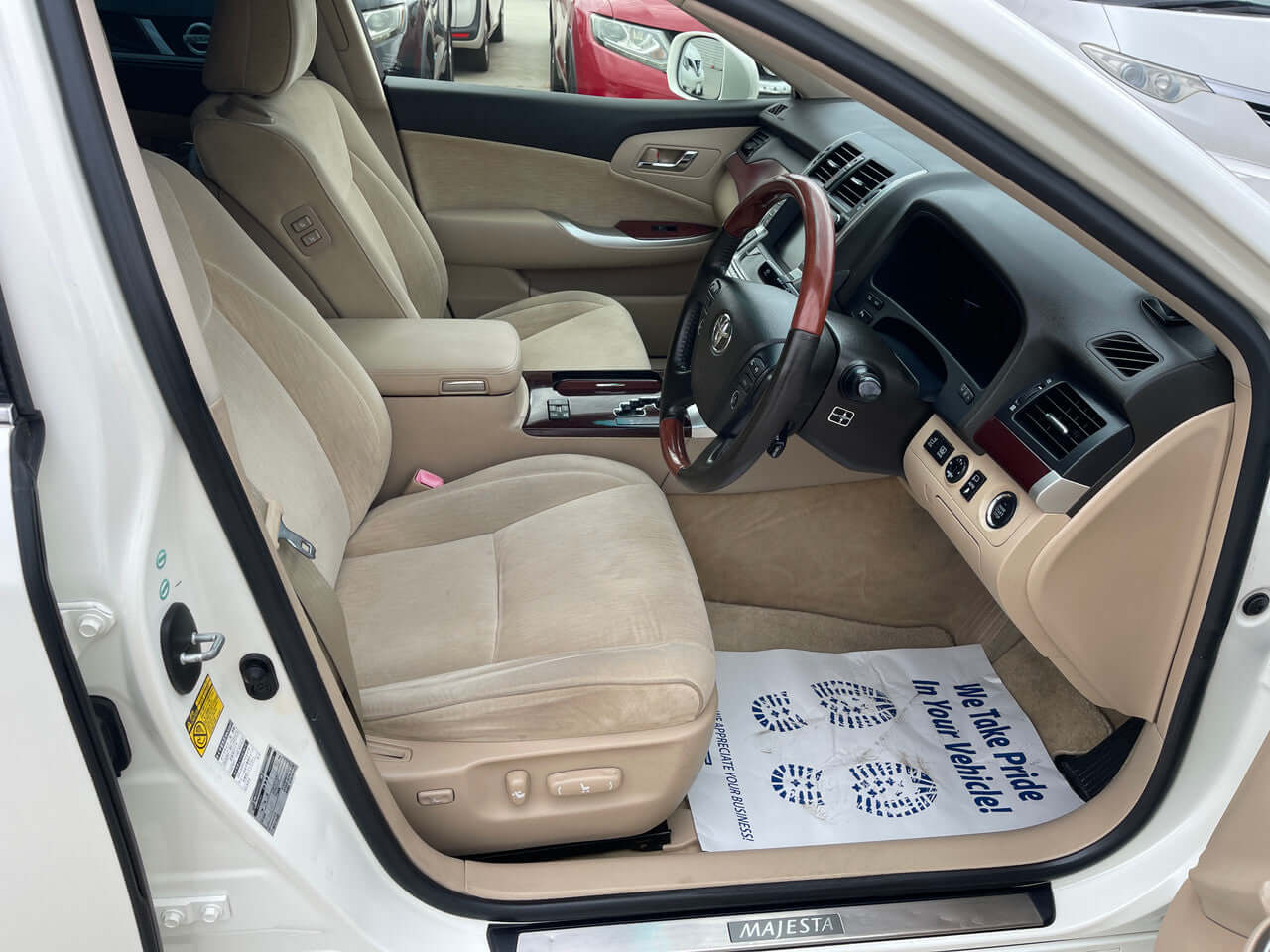 2012 Toyota Crown Majesta V8 4.6L interior featuring plush beige seats and wood grain accents.