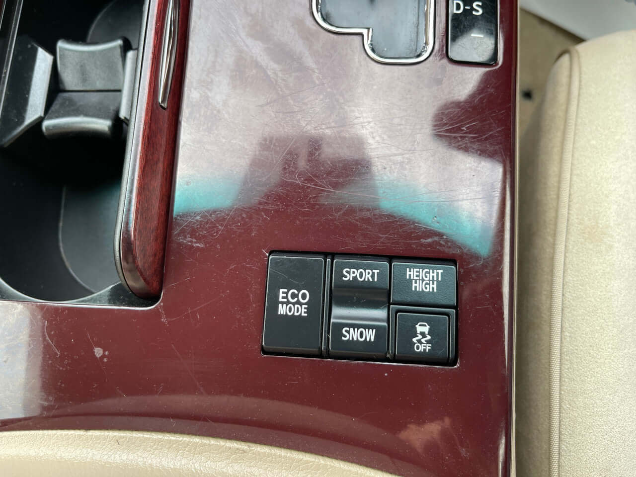 Controls for ECO Mode, Sport, Height High, and Snow settings in the center console of a 2012 Toyota Crown Majesta V8 4.6L.