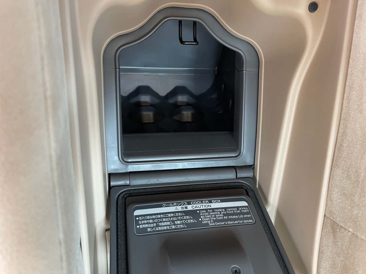 Interior view of the 2012 Toyota Crown Majesta V8 4.6L showing storage compartment and caution label.