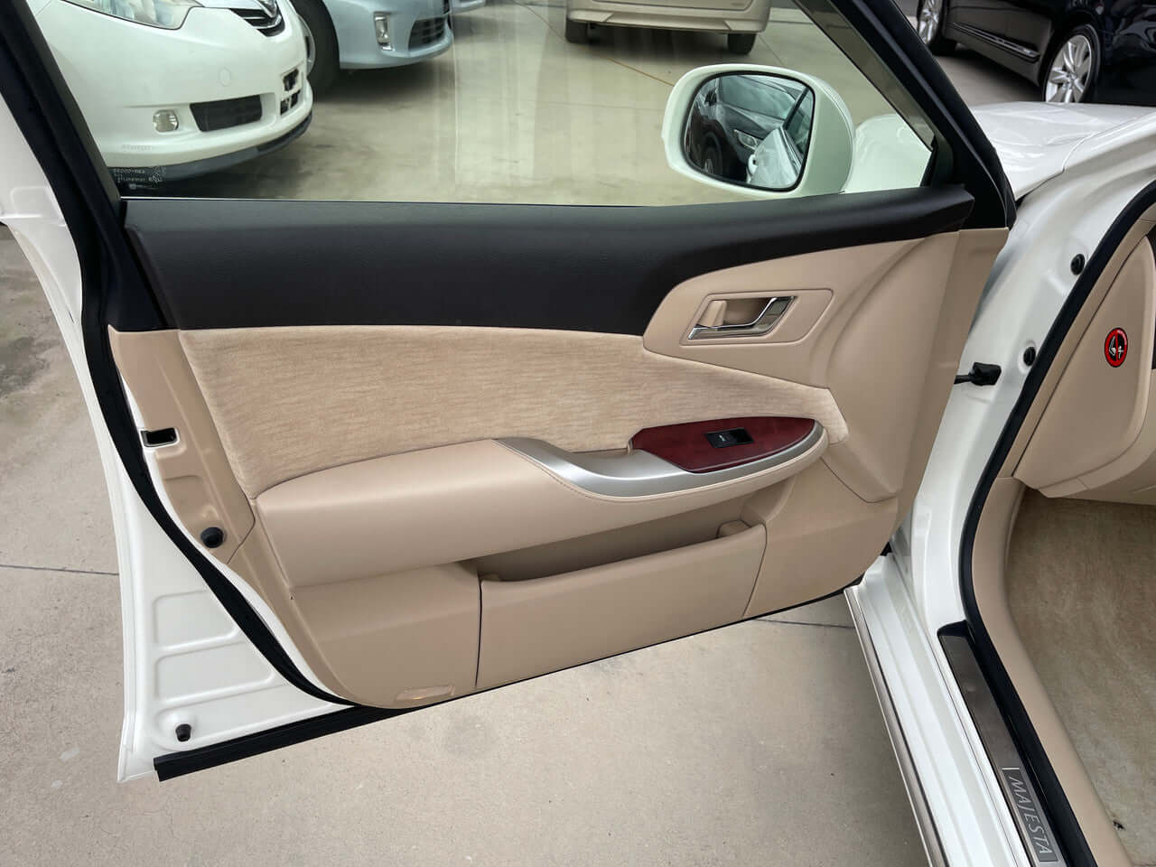 Interior view of the 2012 Toyota Crown Majesta V8 4.6L C Type luxury sedan door panel with beige and wood trim.