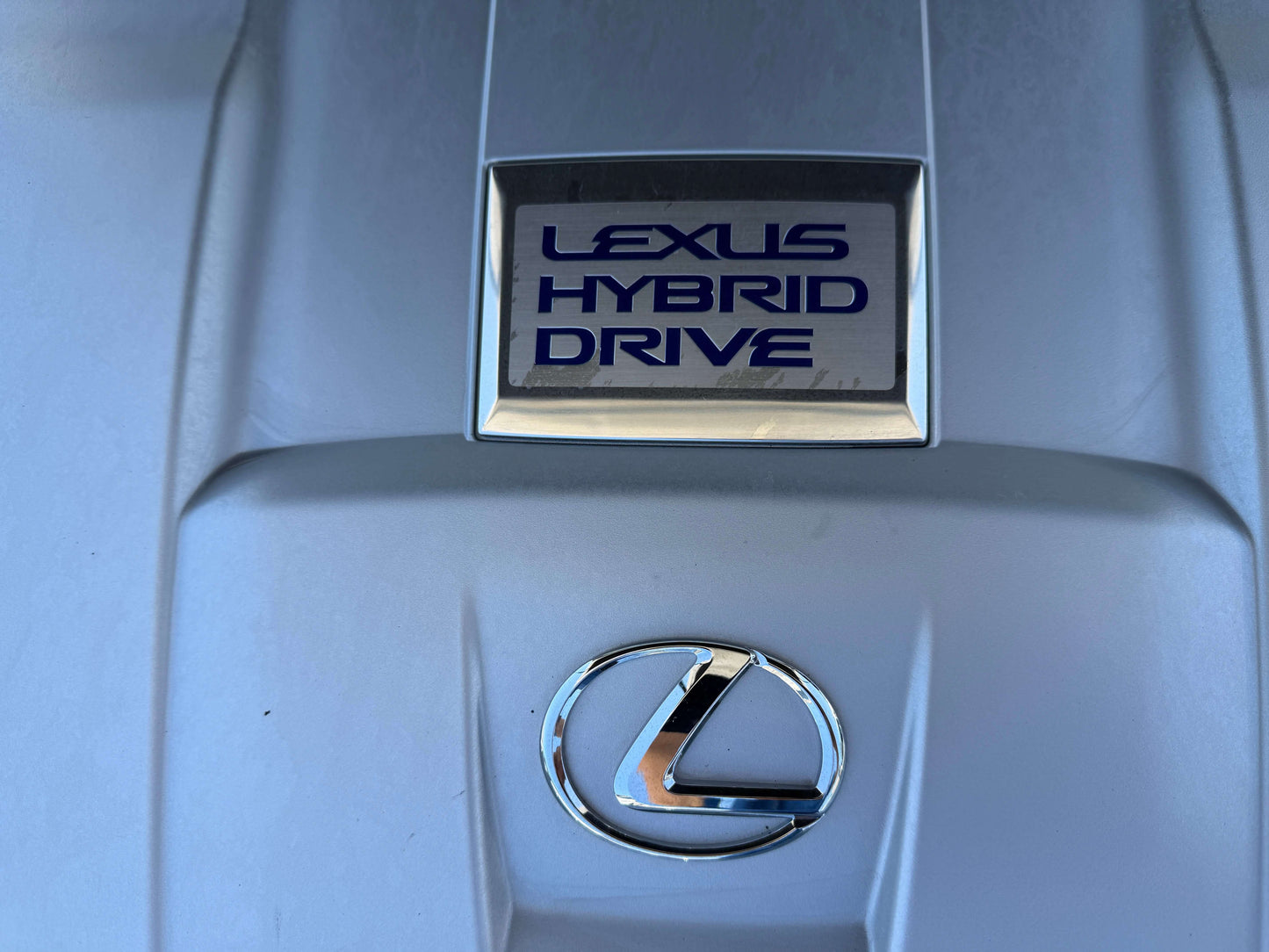 2007 Lexus LS600hL AWD V8 5.0L Hybrid Lexus Hybrid Drive badge on a vehicle engine cover, showcasing hybrid technology and luxury design.