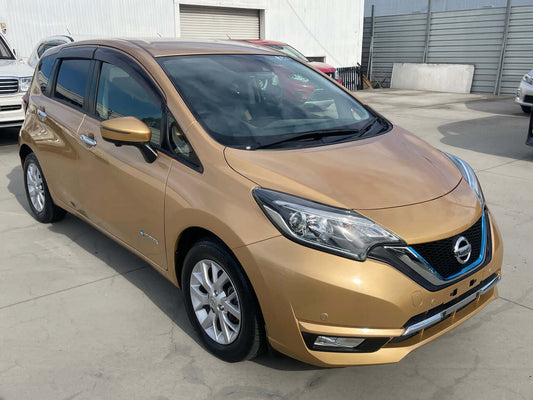 2017 Nissan Note e-Power Medalist Edition in gold color parked at dealership with visible branding.