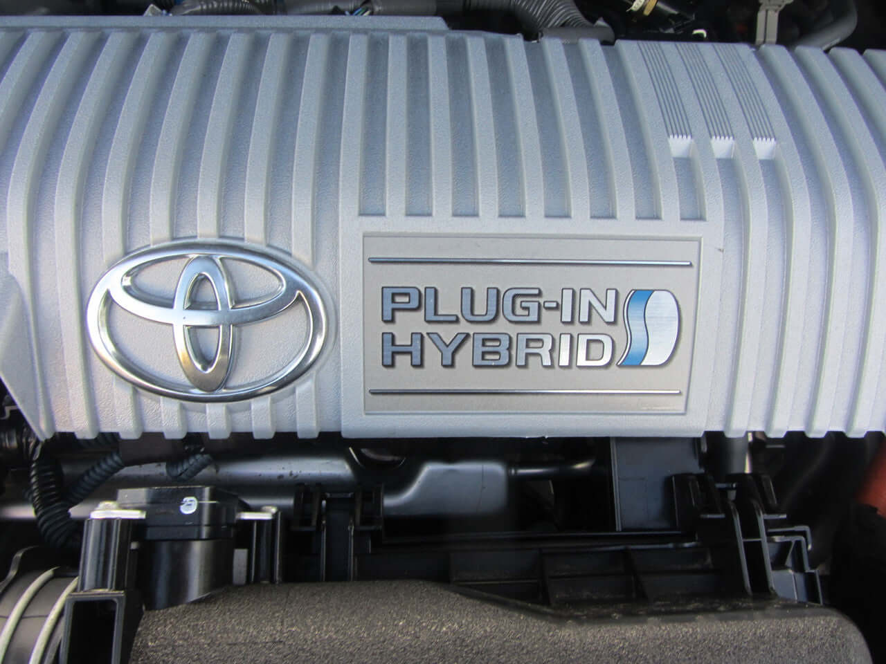 Close-up of the Toyota engine cover with a focus on the Plug-In Hybrid emblem for the 2012 Toyota Prius Plug-In Hybrid 1.8L.