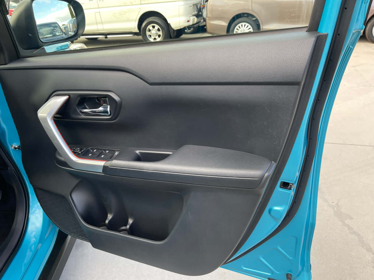 Interior door view of the 2022 Toyota Raize 1.2L e-Smart Hybrid, showcasing a modern design and controls.