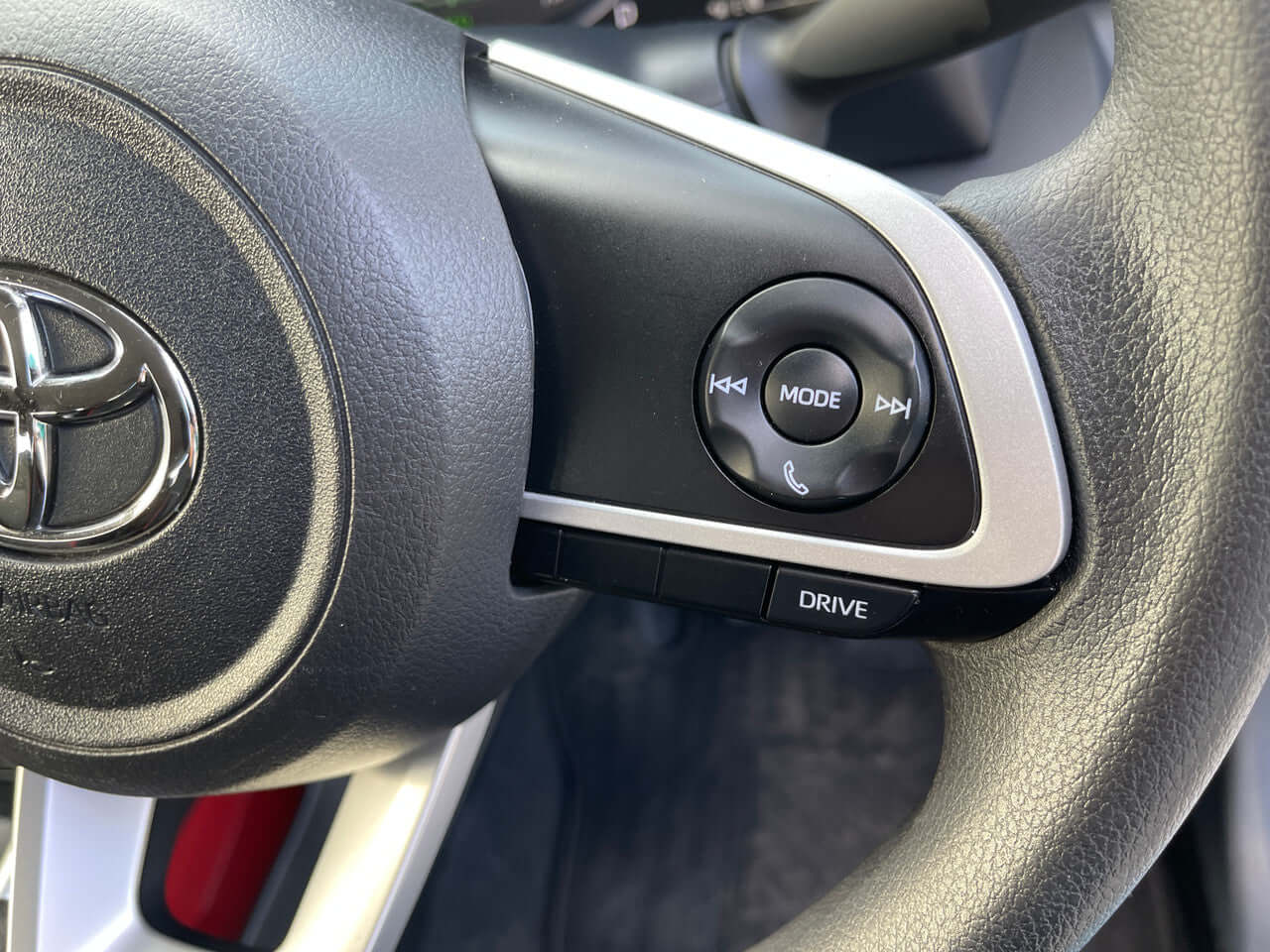 Close-up of the steering wheel controls in a 2022 Toyota Raize 1.2L e-Smart Hybrid featuring drive mode and audio functions.