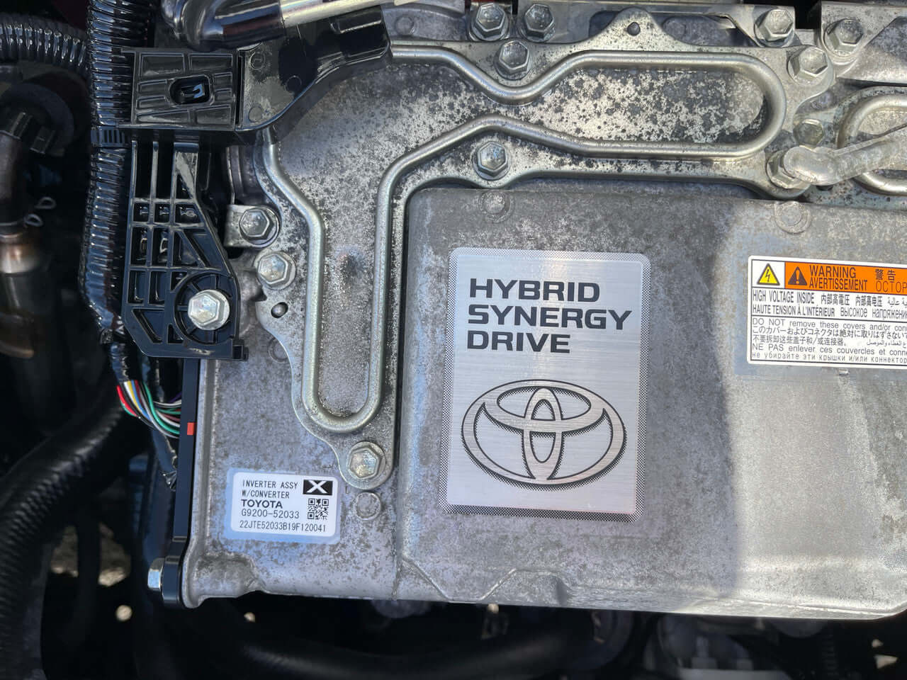 Close-up of the engine component showcasing the Hybrid Synergy Drive logo from a 2019 Toyota Vitz 1.5L Hybrid.