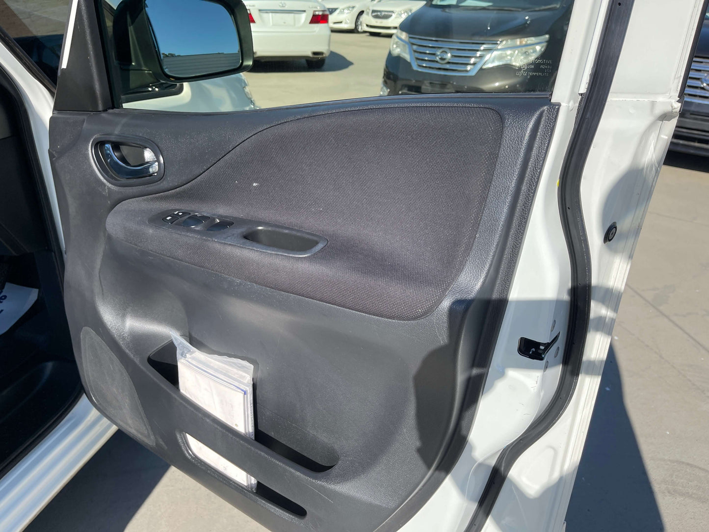 Interior view of a 2015 Nissan Serena 2.0L S-Hybrid door panel showing controls and design.