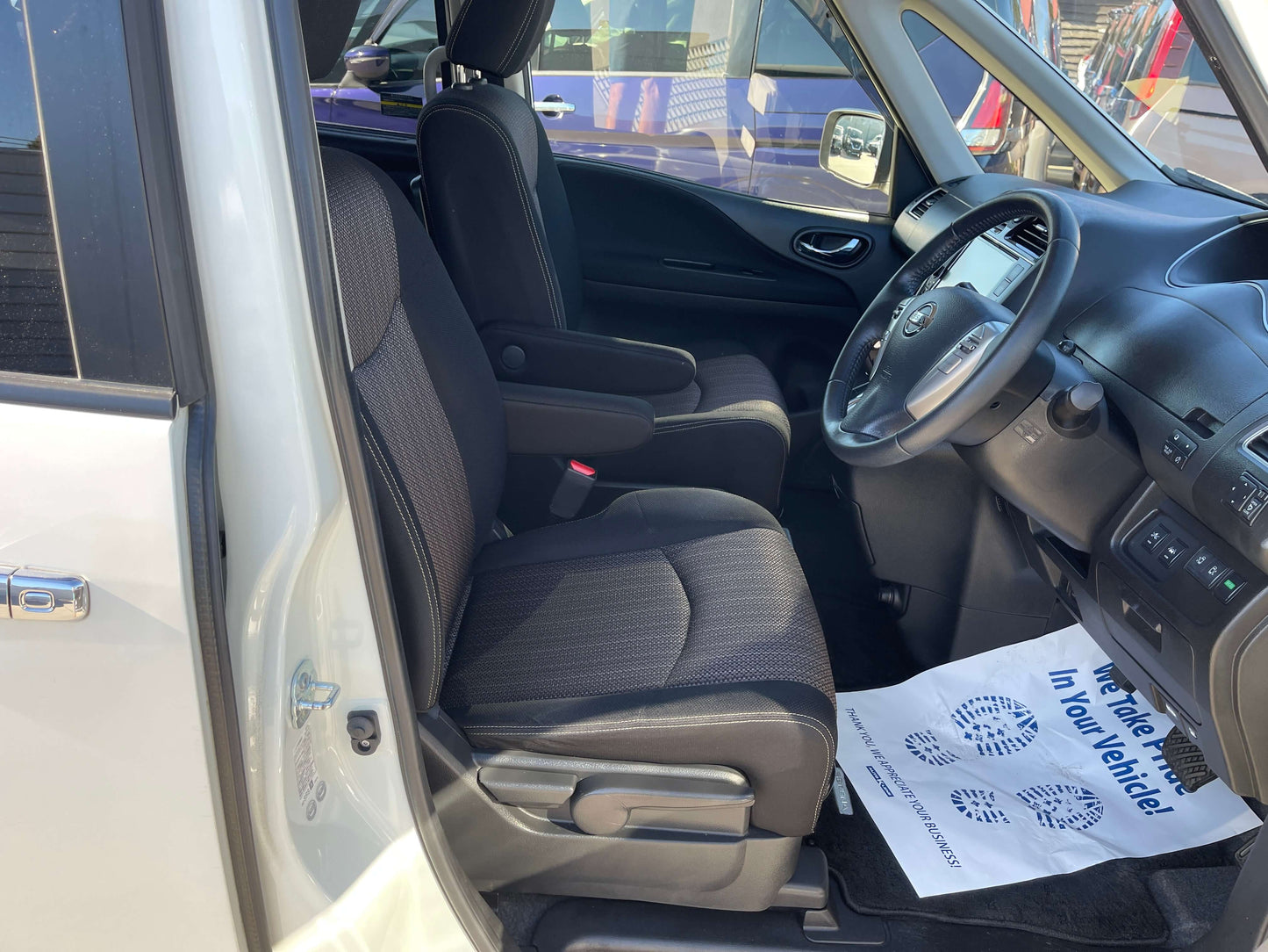 Interior view of 2015 Nissan Serena 2.0L S-Hybrid showing spacious front seats and dashboard.