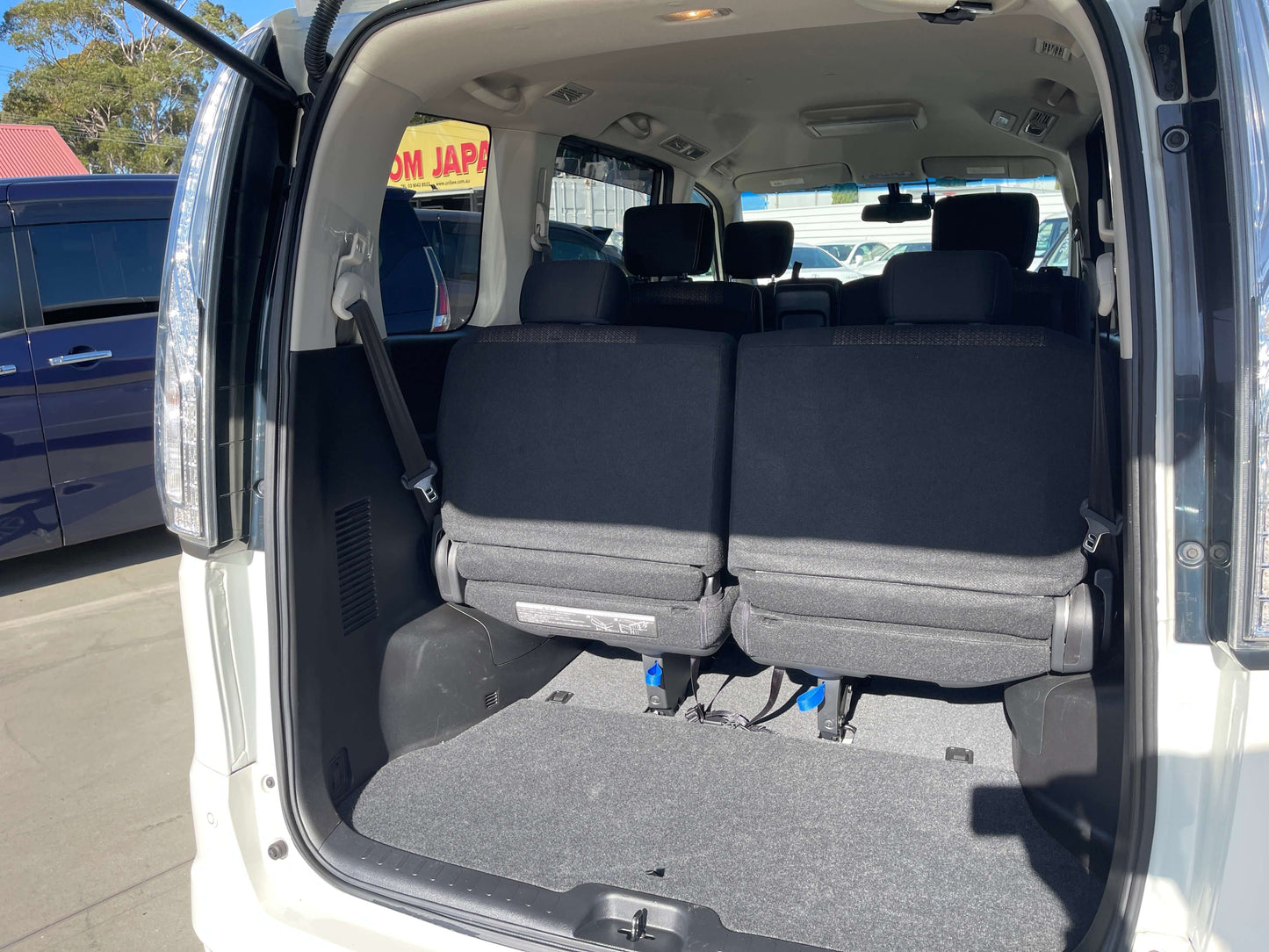 Interior view of the rear seating area in a 2015 Nissan Serena 2.0L S-Hybrid, showcasing spacious seating for 8.