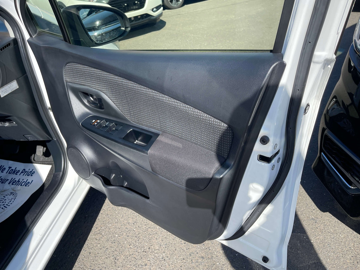Interior view of the 2020 Toyota Vitz 1.5L Hybrid F Safety Edition driver's side door panel showing controls.