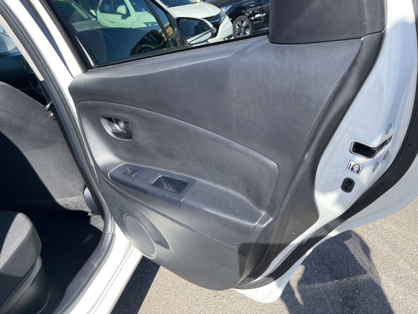 Interior view of the door panel of a 2020 Toyota Vitz 1.5L Hybrid with controls and fabric upholstery.