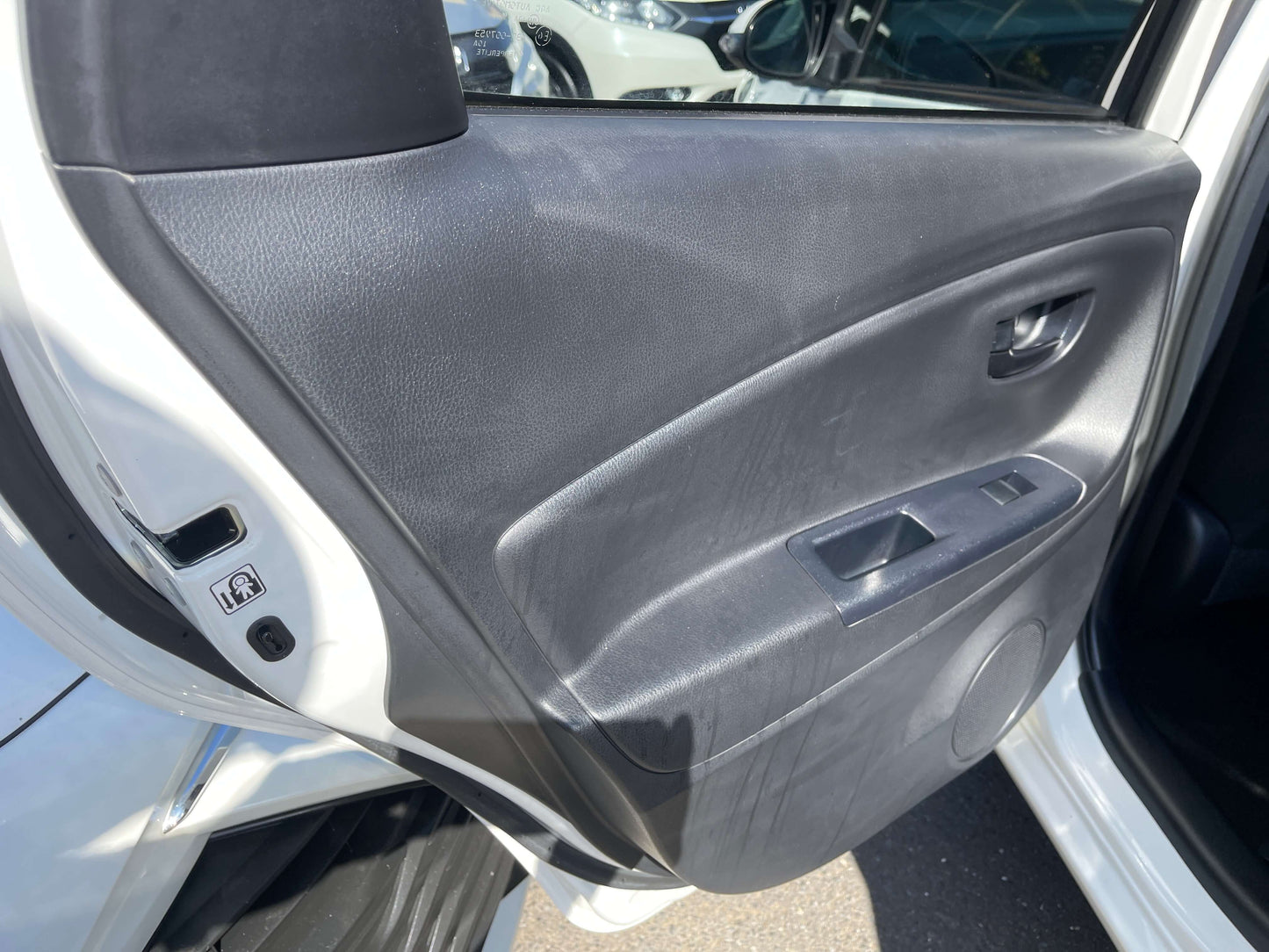 Interior view of the 2020 Toyota Vitz 1.5L Hybrid F Safety Edition driver's side door panel.