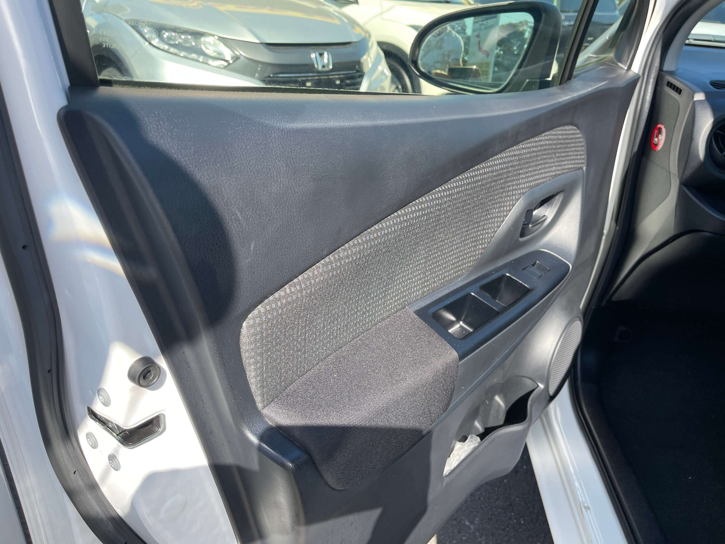 Interior door panel of a 2020 Toyota Vitz 1.5L Hybrid F Safety Edition with modern design features.