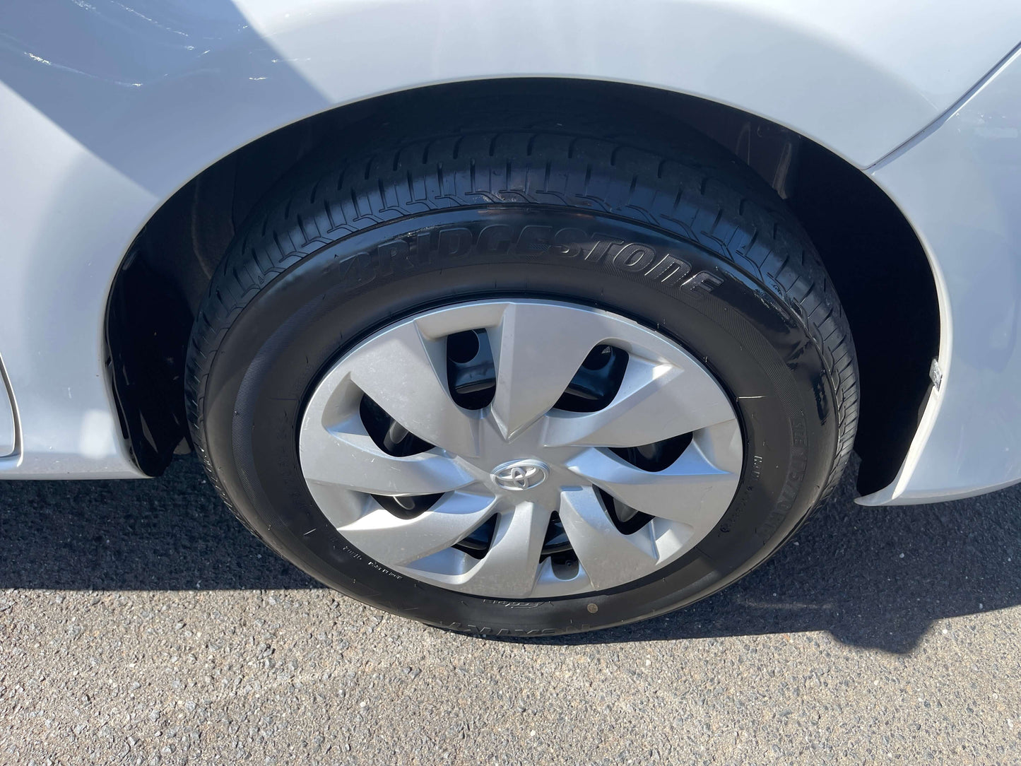 Close-up of the wheel with alloy rims on a 2020 Toyota Vitz 1.5L Hybrid, showcasing tire tread and design details.