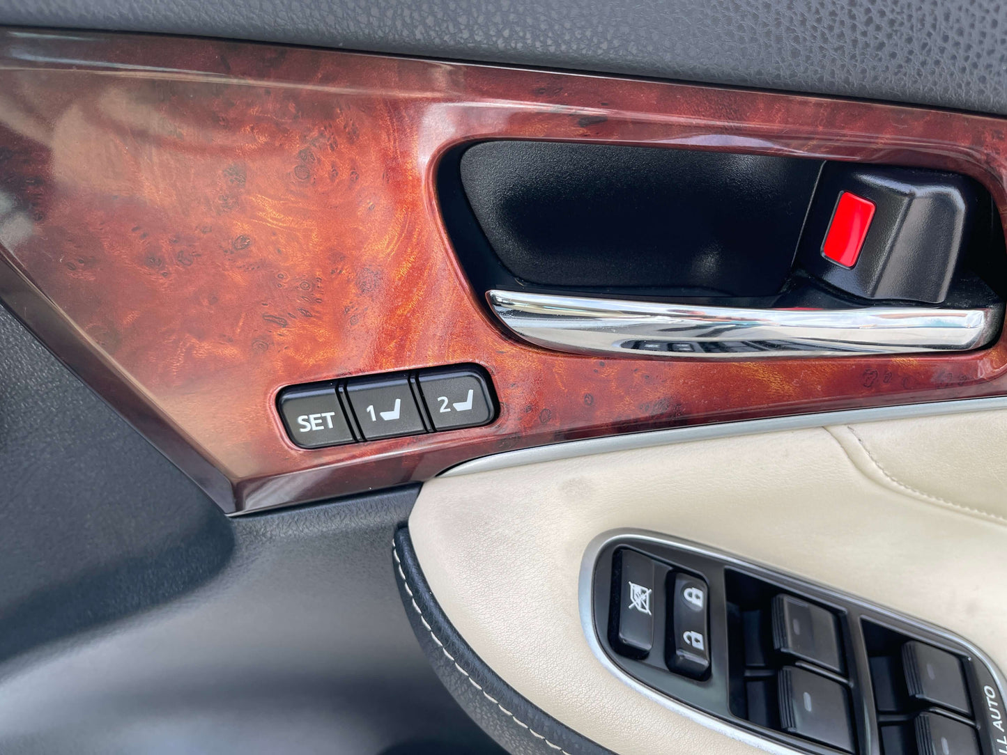 Interior detail of 2014 Toyota Crown Majesta V6 3.5L Hybrid showing luxury door controls and wood trim.