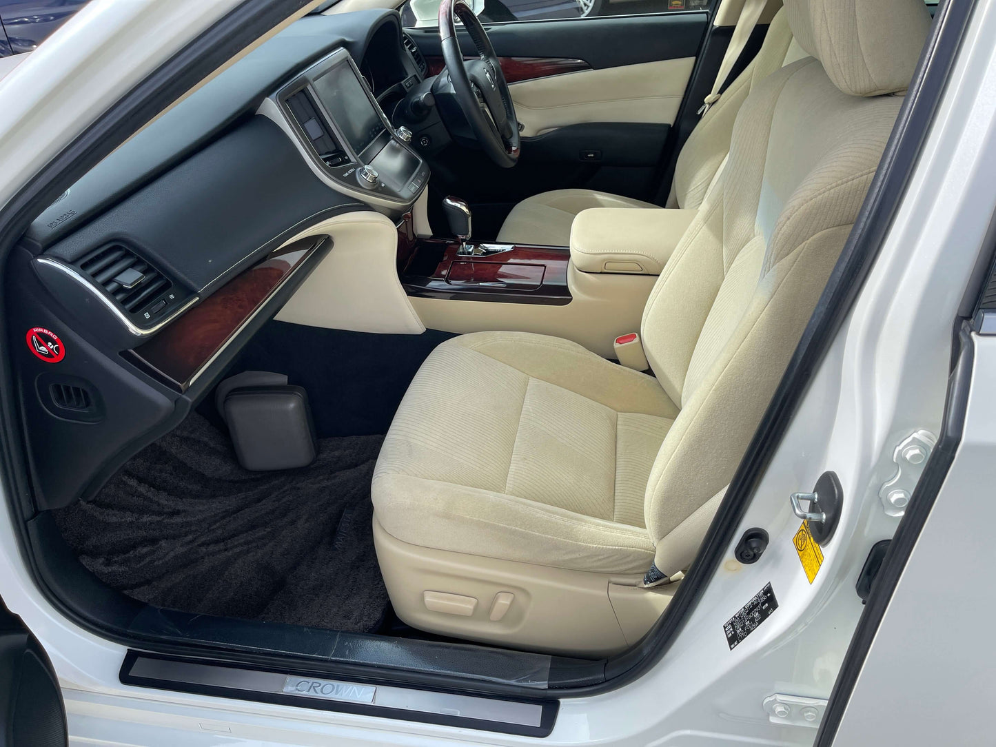 Interior view of 2014 Toyota Crown Majesta V6 3.5L Hybrid Luxury Sedan showing plush beige seats and wood accents.