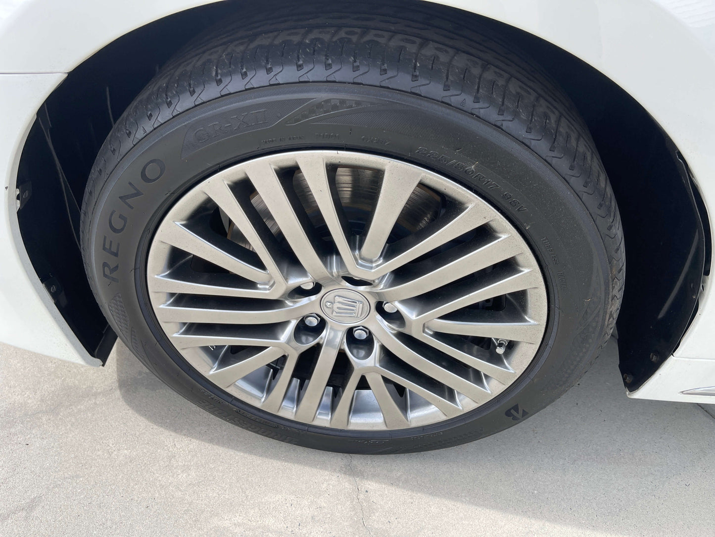 Close-up of a 2014 Toyota Crown Majesta V6 3.5L Hybrid luxury sedan wheel and tire.