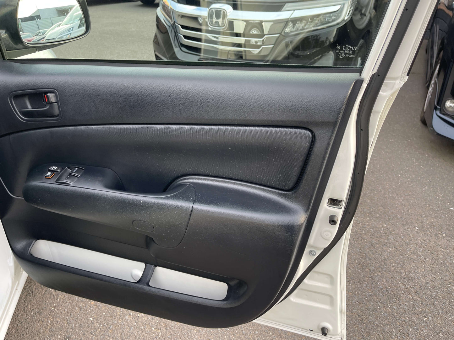 Interior view of 2020 Toyota Probox Hybrid 1.5L Station Wagon door panel showing controls and design.