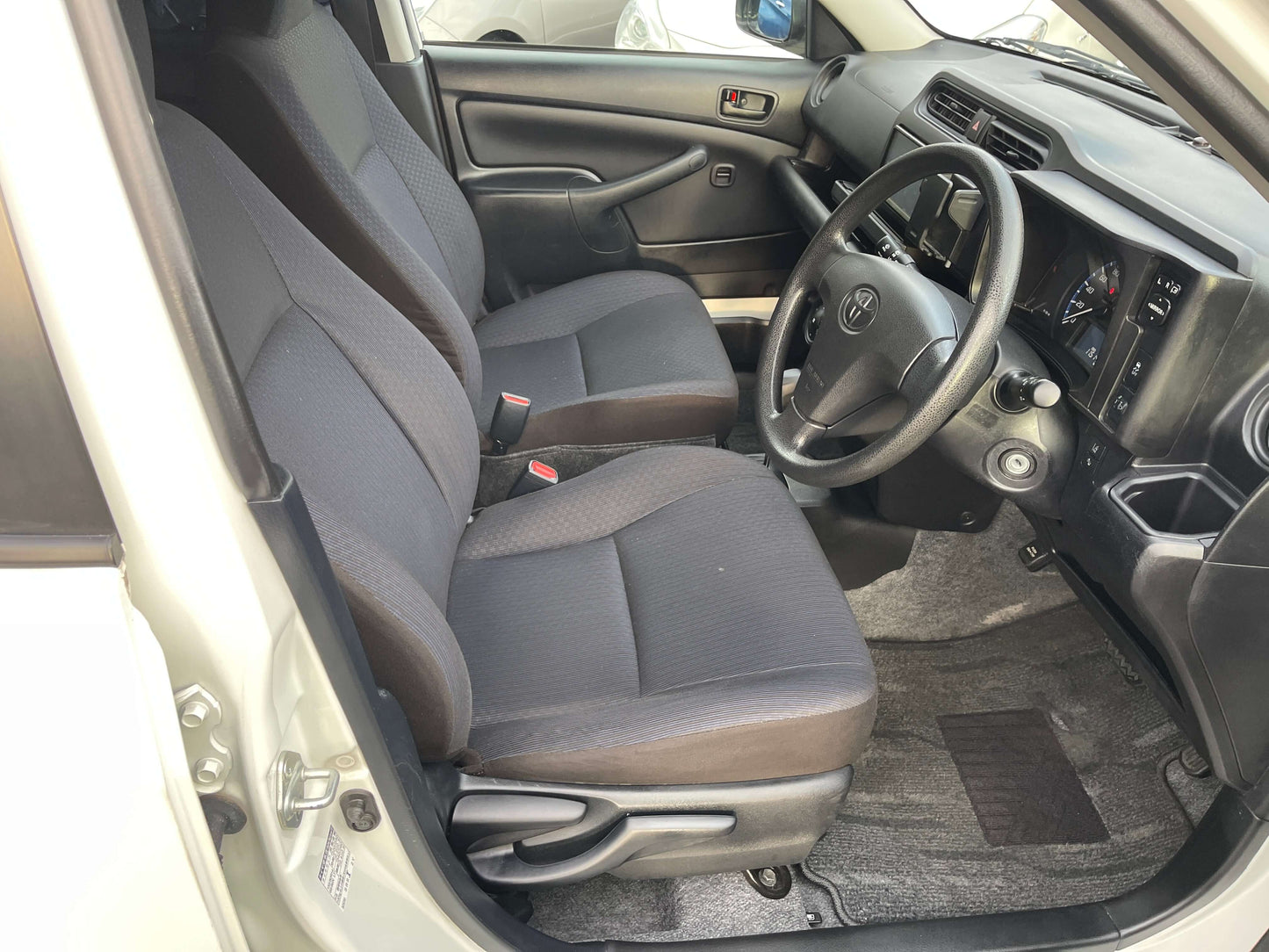 Interior view of 2020 Toyota Probox Hybrid 1.5L Station Wagon showing front seats and dashboard.