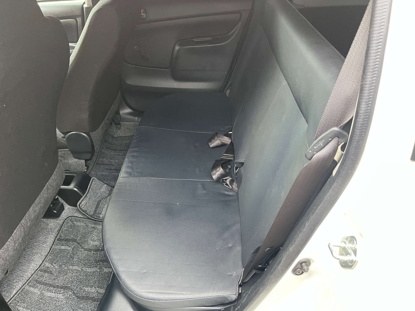 Interior view of the back seat of a 2020 Toyota Probox Hybrid 1.5L Station Wagon showing spacious seating.