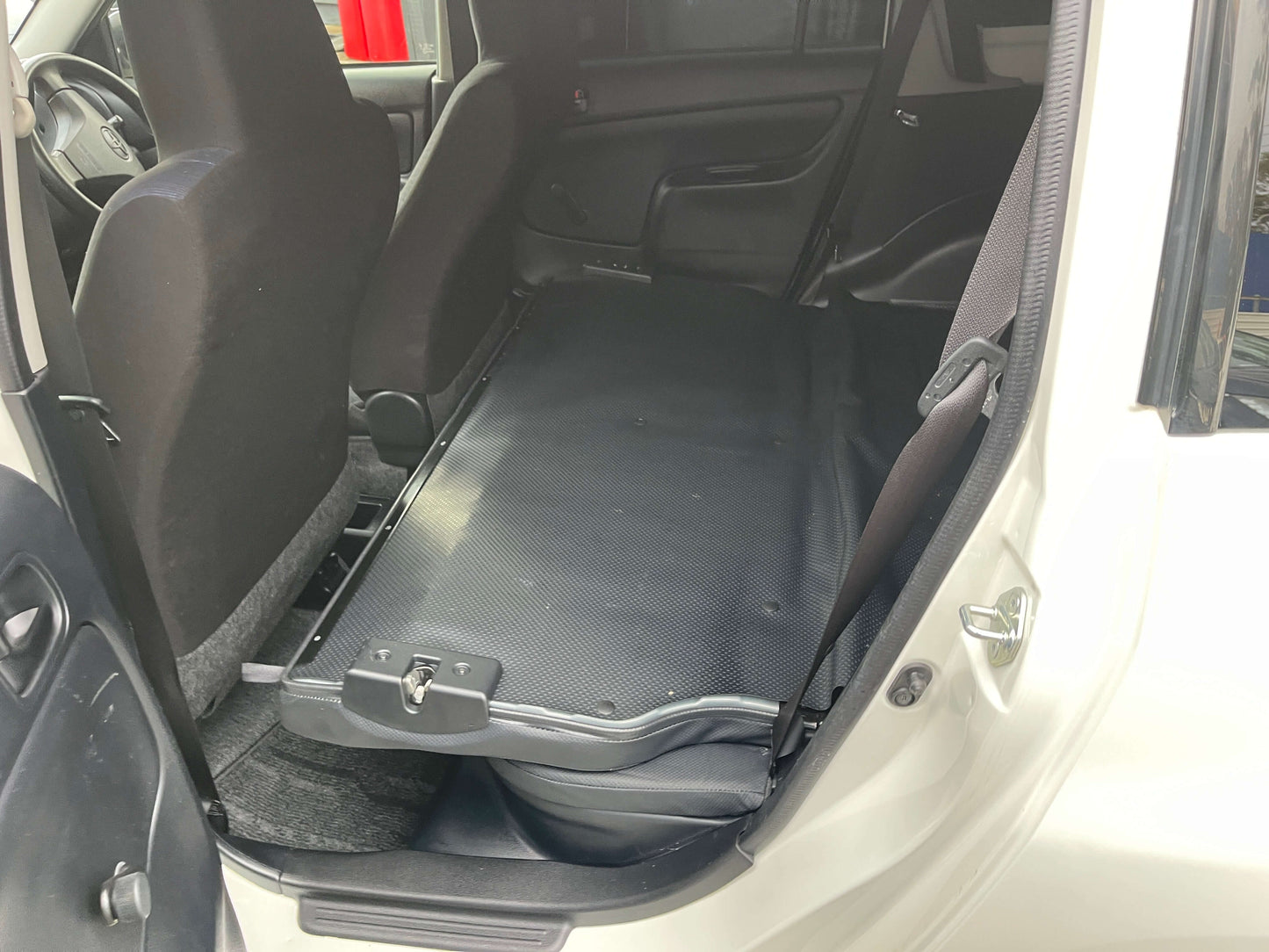 Interior view of back seat area in 2020 Toyota Probox Hybrid 1.5L Station Wagon with flat folded seats.