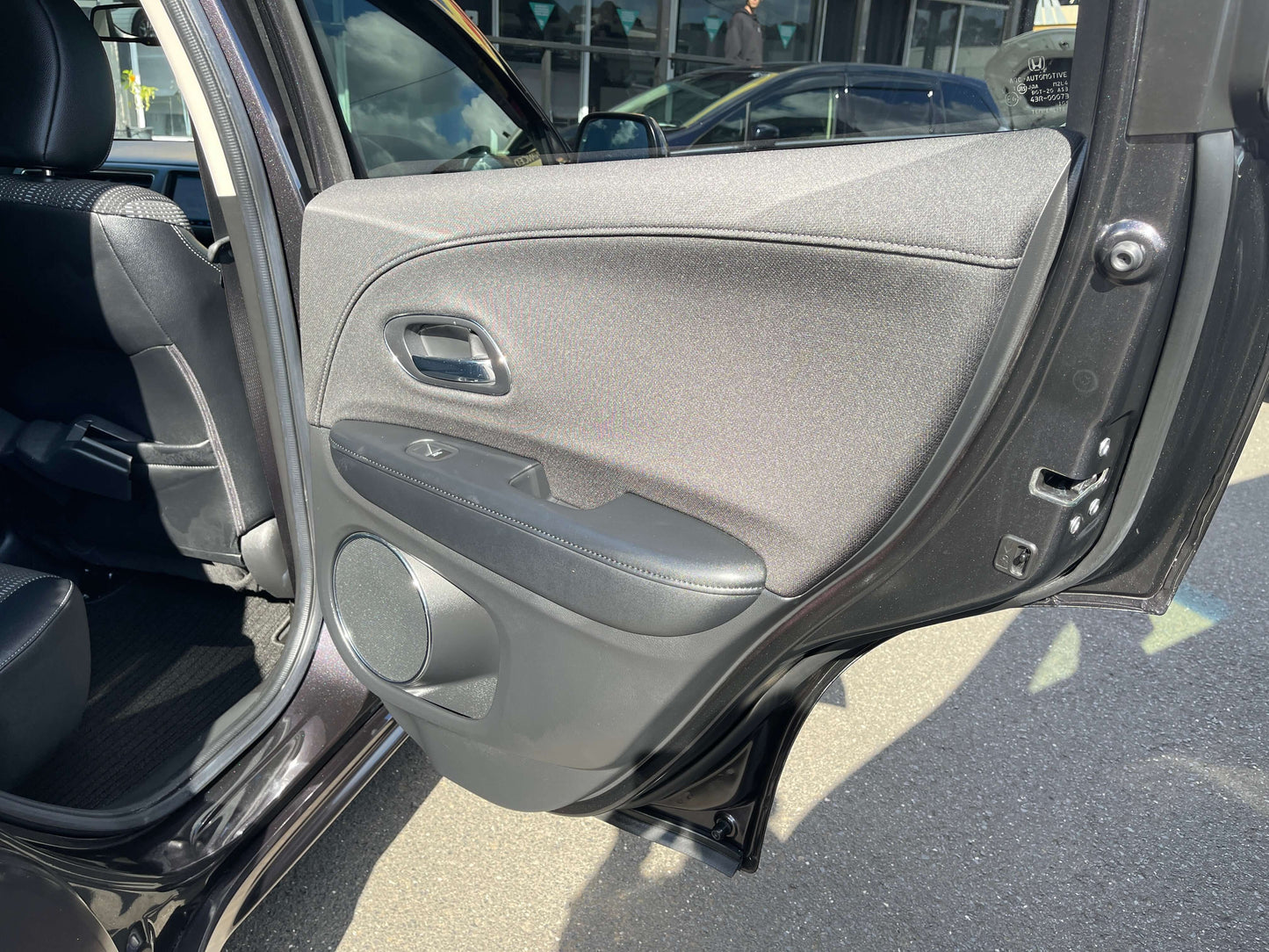 Interior view of the 2014 Honda Vezel HR-V Hybrid Z SUV door panel showcasing fabric and controls.