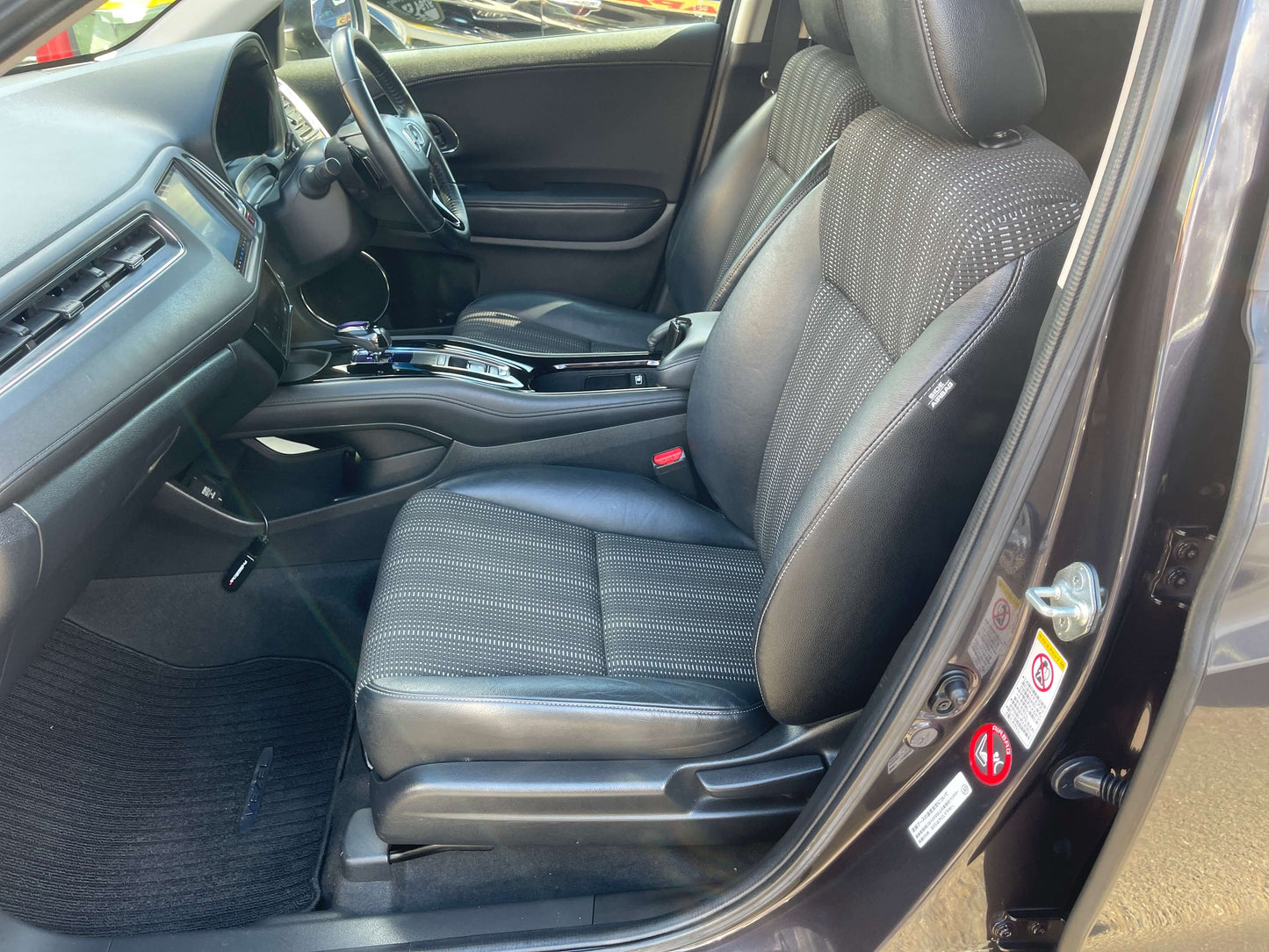Interior view of the 2014 Honda Vezel HR-V Hybrid Z SUV showing front seats and dashboard details.