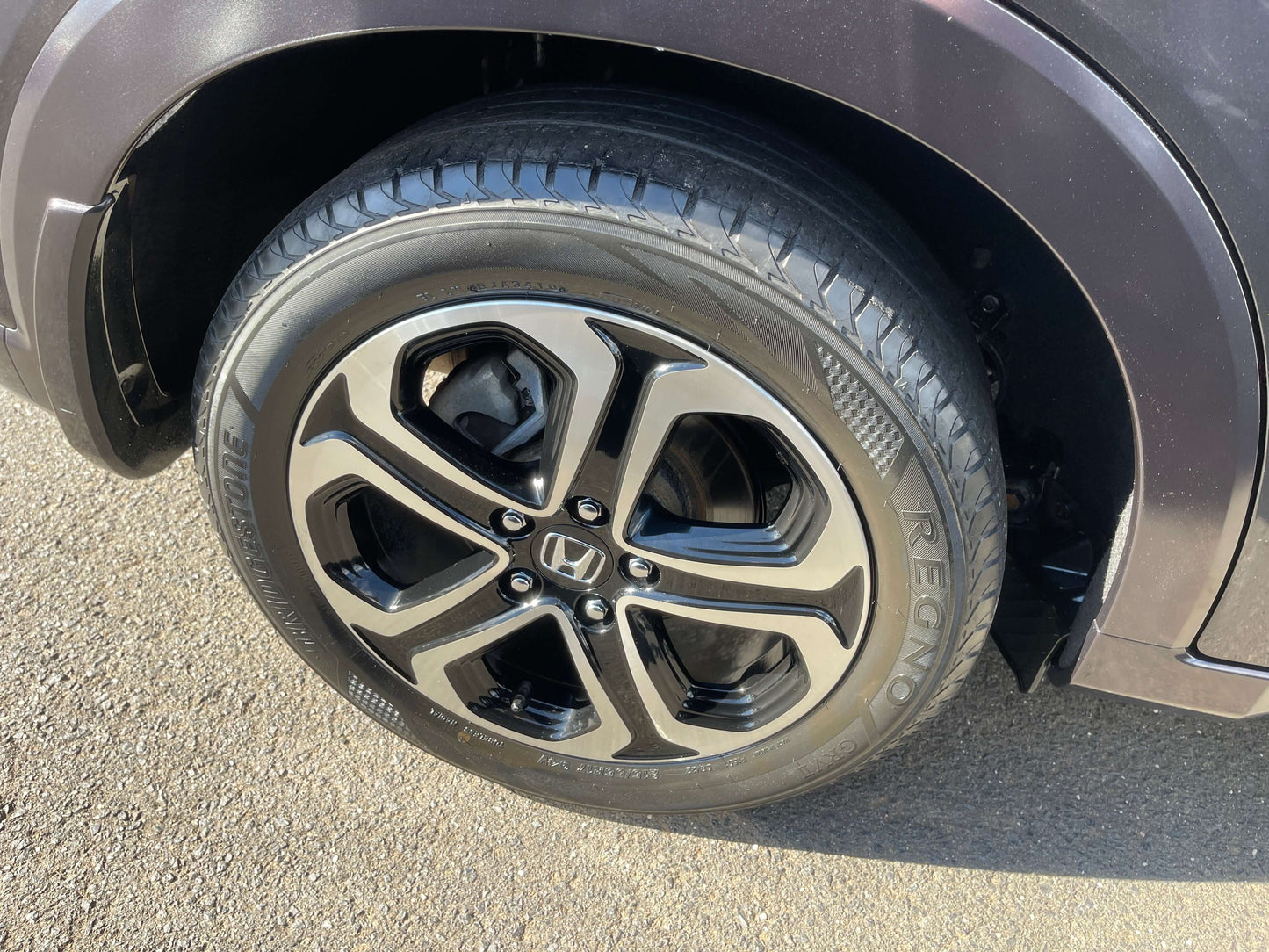 Close-up of a stylish alloy wheel on a 2014 Honda Vezel HR-V Hybrid SUV, showcasing its modern design.