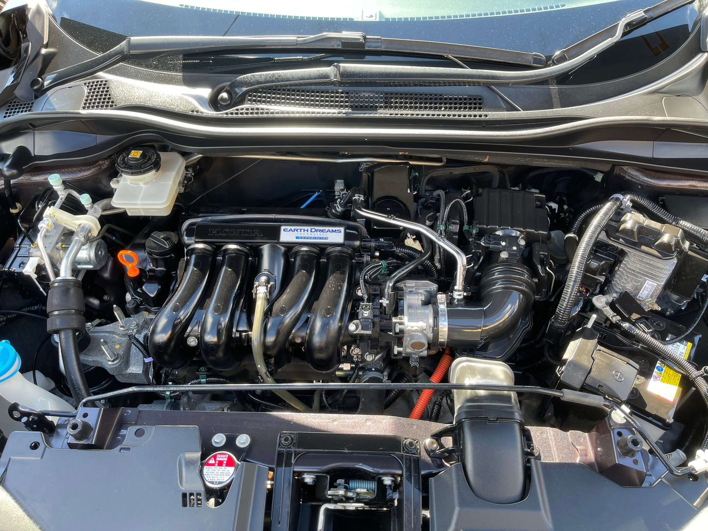 Engine compartment of a 2014 Honda Vezel HR-V Hybrid showing its efficient components.