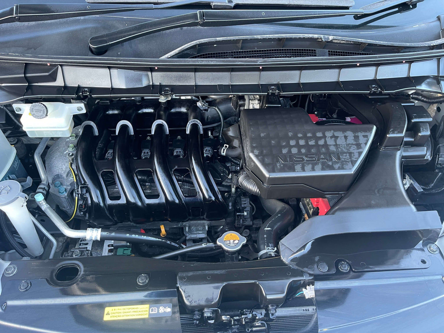 Engine compartment of a 2016 Nissan Serena 2.0L S-Hybrid showcasing the hybrid engine components and design.