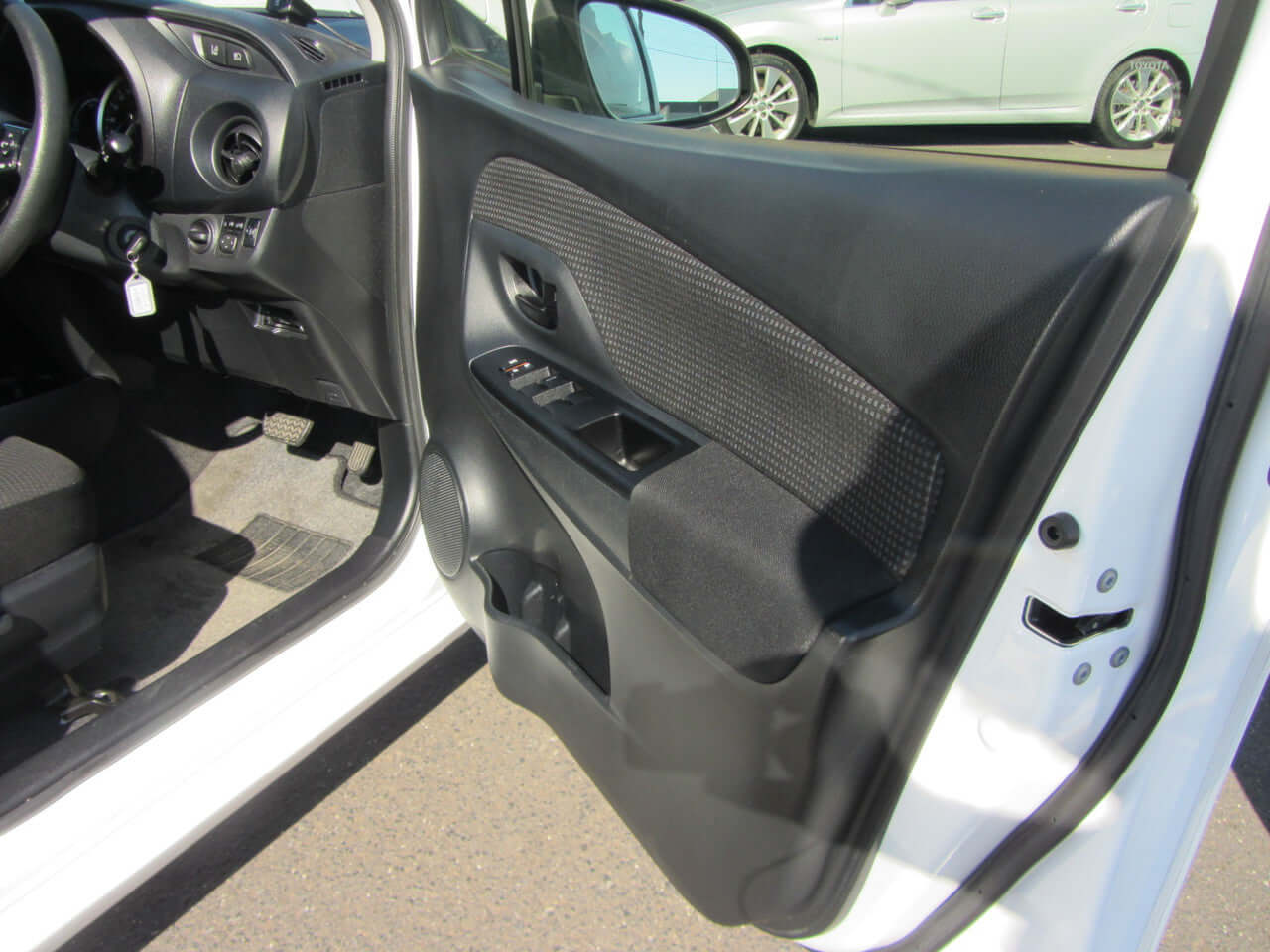 Interior view of the 2018 Toyota Vitz 1.5L Hybrid showing the driver's door and control panel.