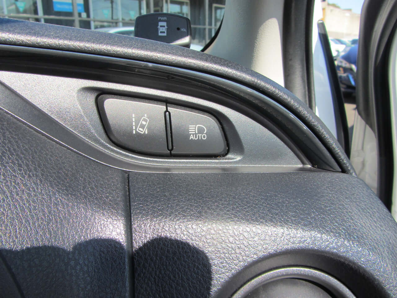 Close-up of the control panel in a 2018 Toyota Vitz 1.5L Hybrid, featuring automatic light control settings.