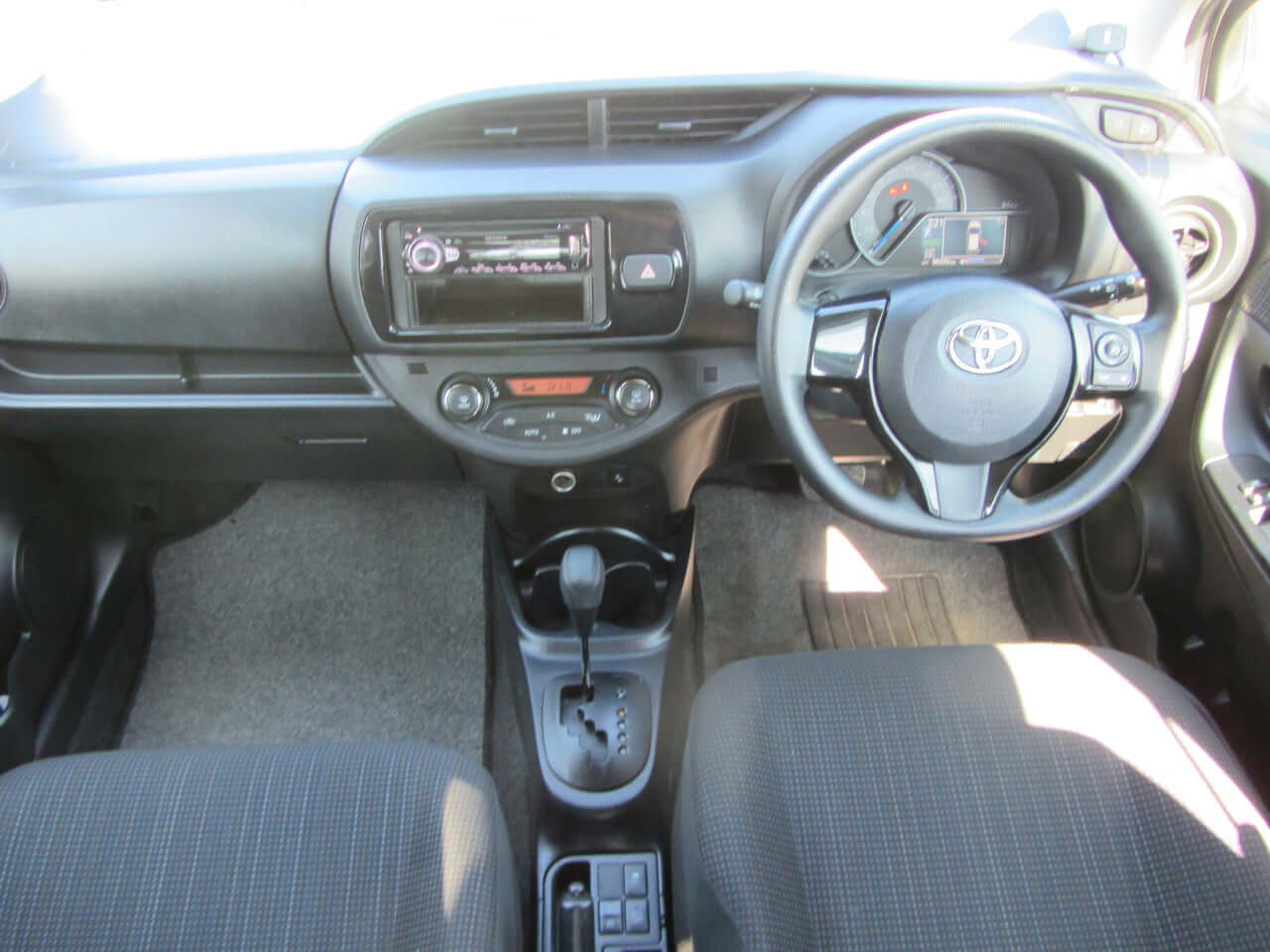 Interior view of 2018 Toyota Vitz 1.5L Hybrid with dashboard controls and seats.