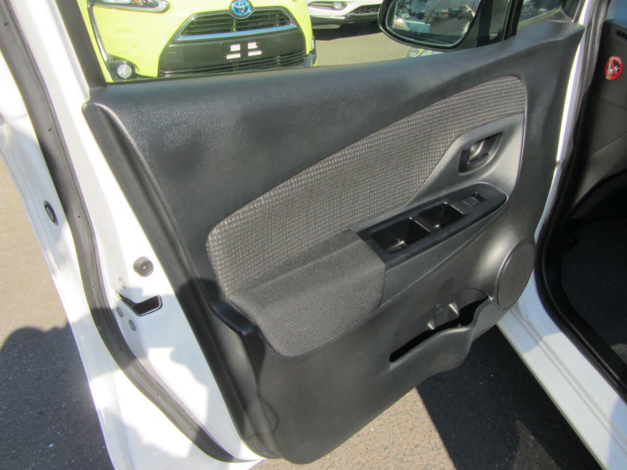 Interior view of 2018 Toyota Vitz 1.5L Hybrid door panel showcasing sleek design and features.