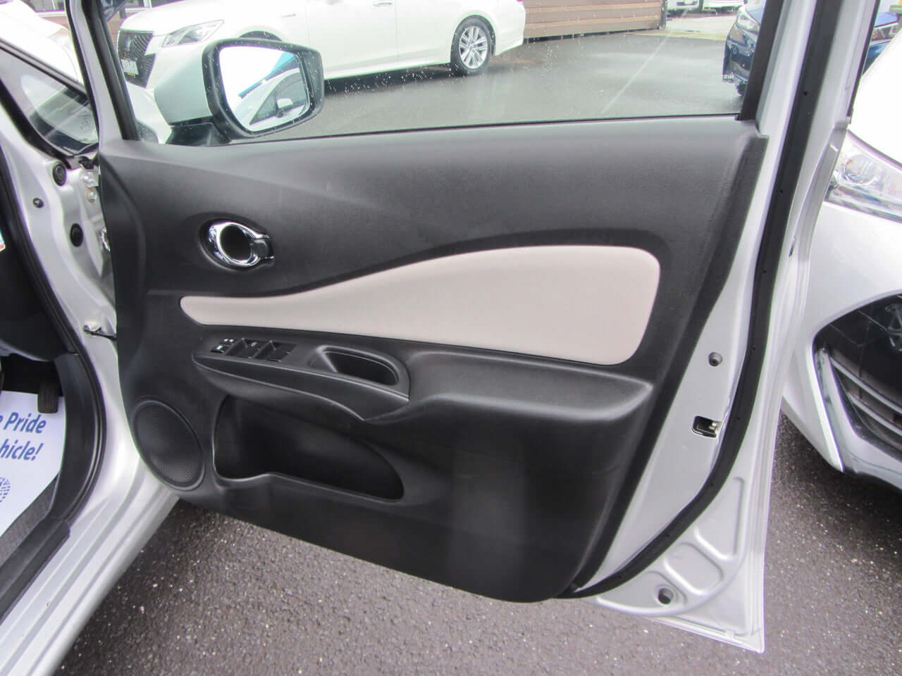 Interior view of the door panel of a 2019 Nissan Note e-Power G Edition with black and beige accents.
