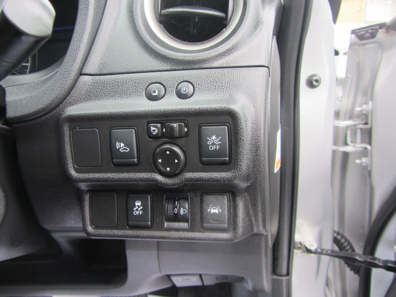 Control panel with various buttons in a 2019 Nissan Note e-Power interior, featuring settings for driving assistance and lights.