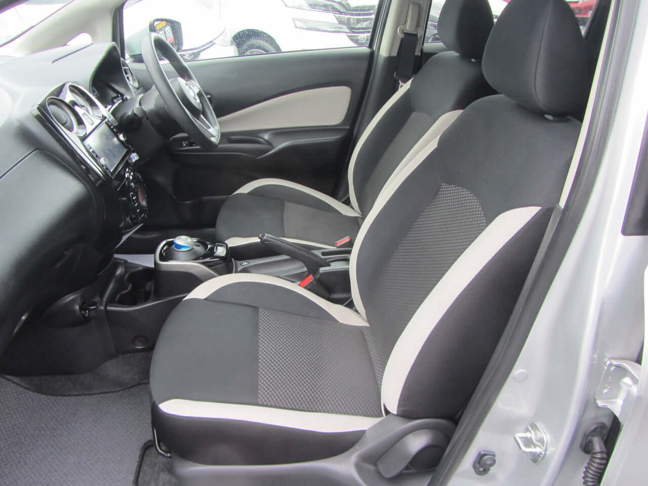 Interior view of a 2019 Nissan Note e-Power G Edition, showcasing black and grey seats with modern design.