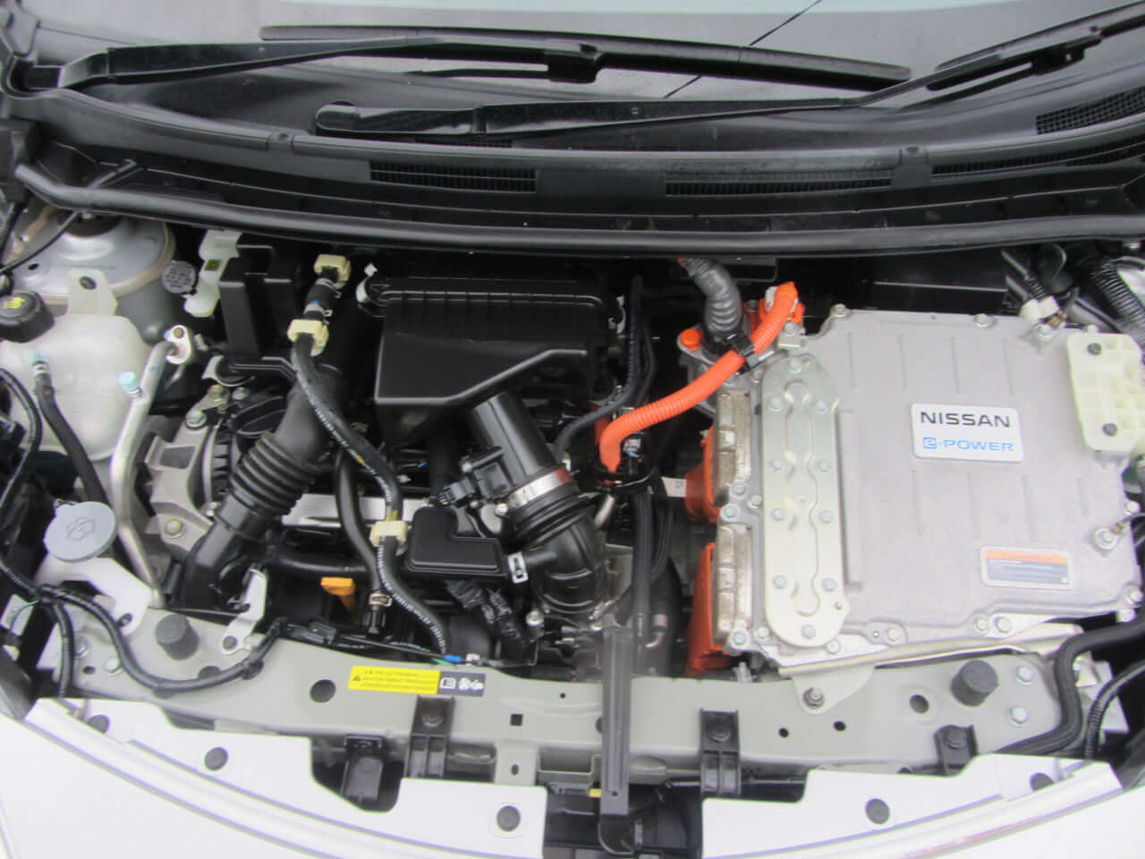 Engine compartment of 2019 Nissan Note e-Power showing hybrid components and design.
