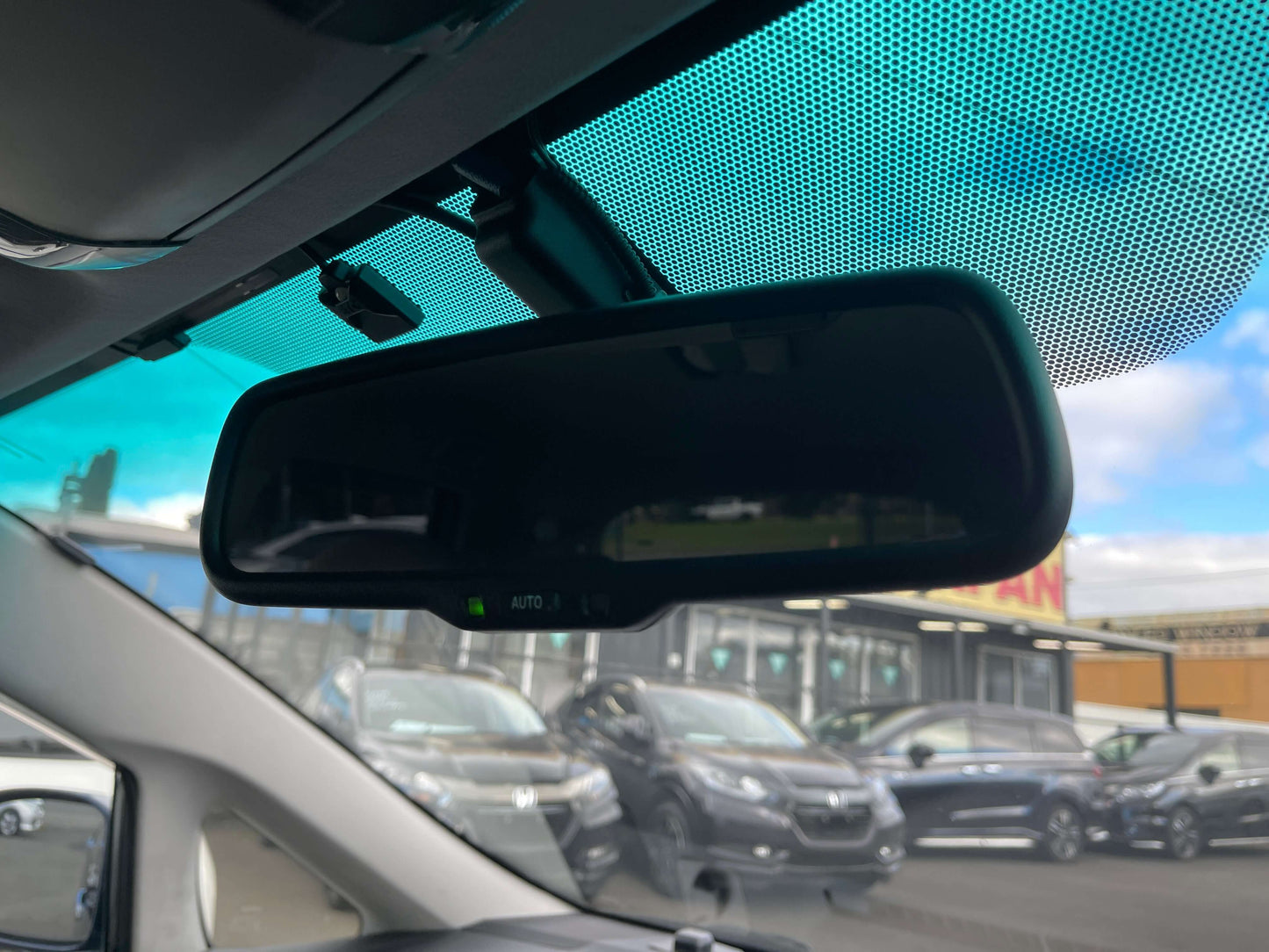 2008 Toyota Mark X Zio V6 3.5L Interior view of the rearview mirror in a car, showcasing the auto-dimming feature and surrounding vehicles in the background.