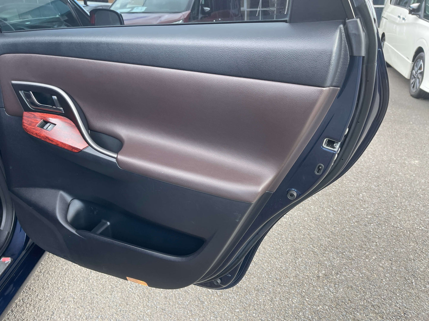 Interior view of the brown door panel of a 2008 Toyota Mark X Zio V6 3.5L, showcasing wood trim and handles.