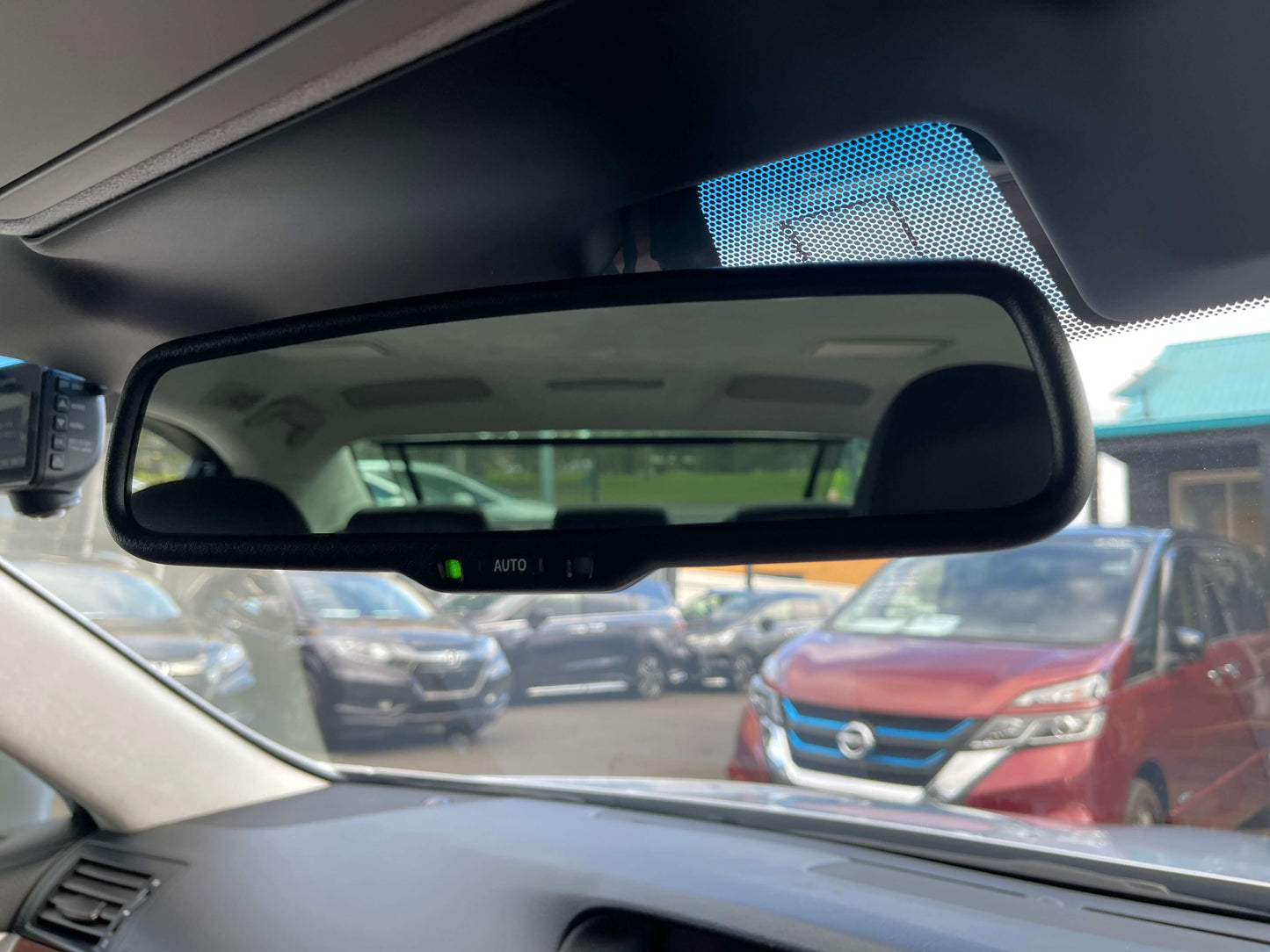 2015 Lexus LS460 AWD V8 4.6L Interior view of rearview mirror showing parking area with various vehicles behind, enhancing safety features.