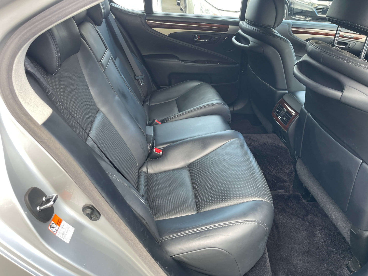 Interior view of the back seat of a 2015 Lexus LS460 AWD V8 4.6L luxury sedan, showcasing plush black leather seating.