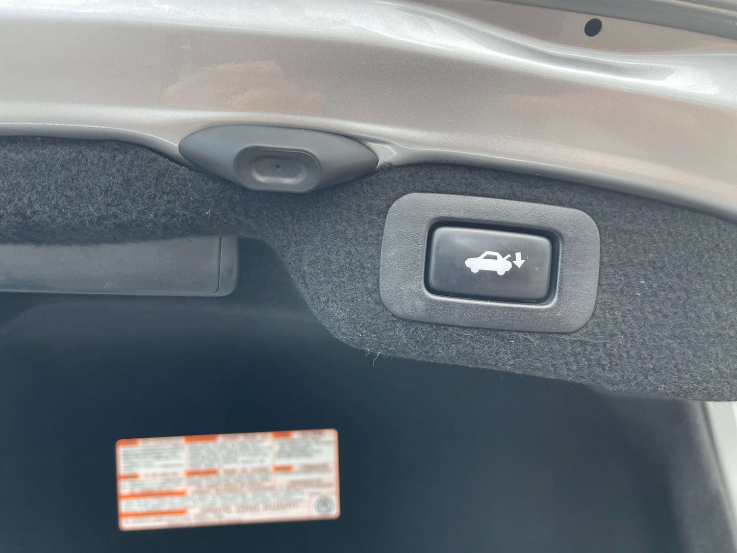 Button for opening trunk in a 2015 Lexus LS460 AWD V8 4.6L luxury sedan.