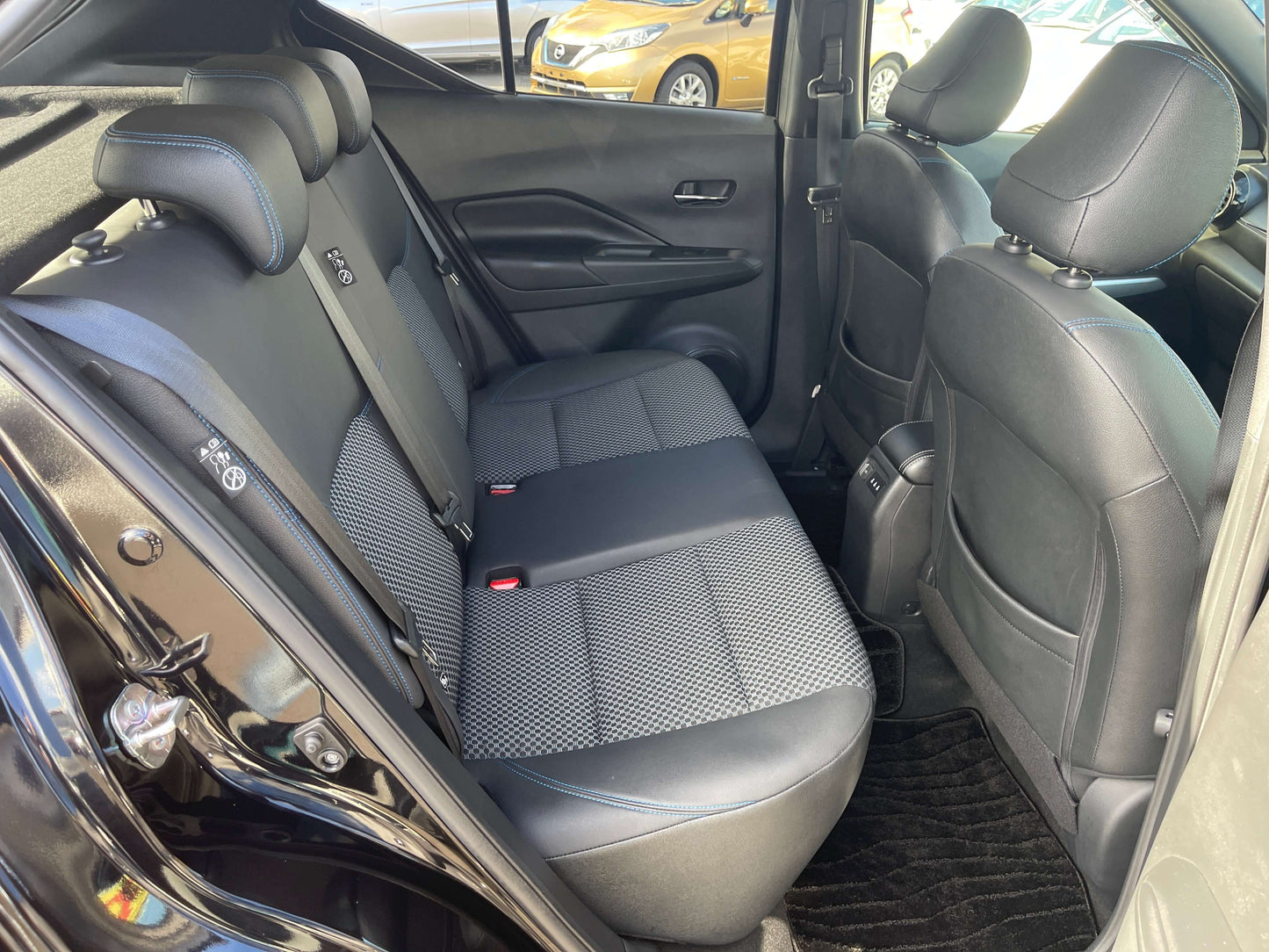 Interior view of the backseat of a 2020 Nissan Kicks e-Power, featuring black upholstery and comfortable seating.