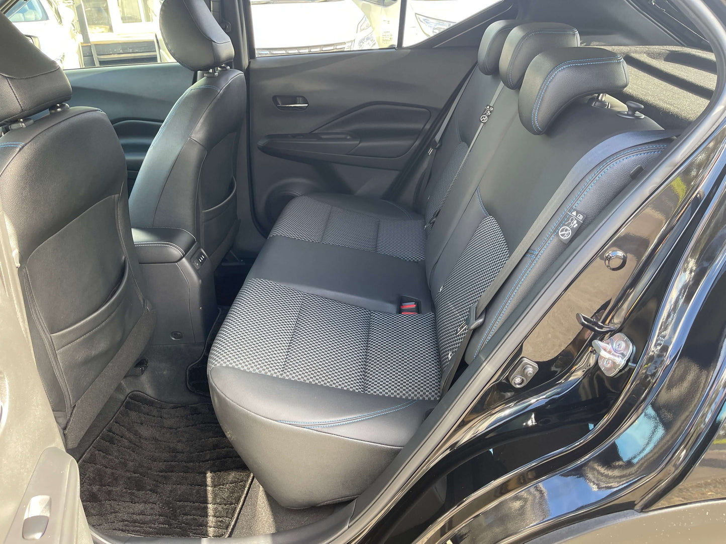 Interior view of the rear seats in a 2020 Nissan Kicks e-Power X Edition showcasing spacious black fabric upholstery.