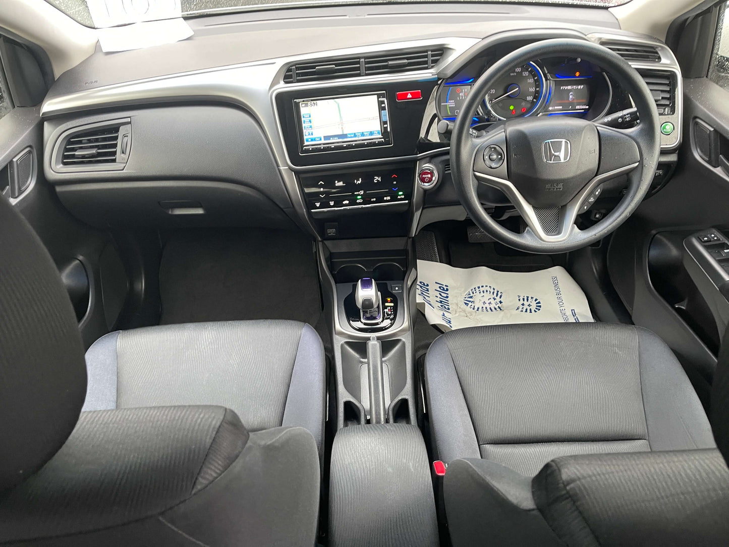 Interior view of the 2015 Honda Grace 1.5 Hybrid DX sedan showing dashboard, seats, and modern features.