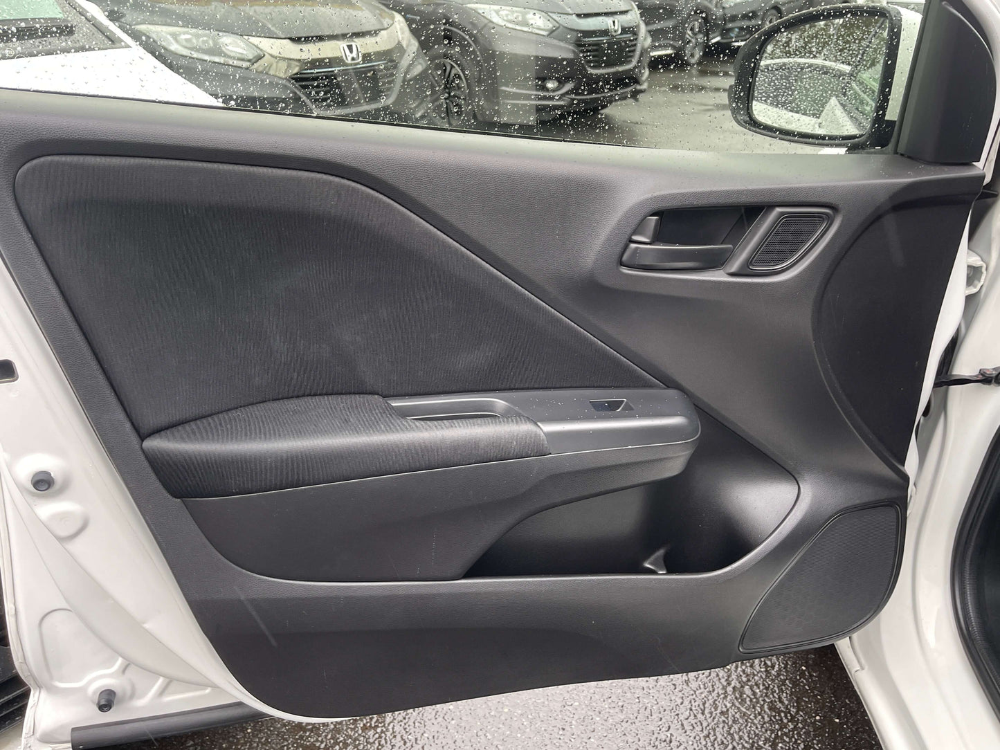 Interior view of the door panel of a 2015 Honda Grace 1.5 Hybrid DX Sedan featuring modern design and comfort.