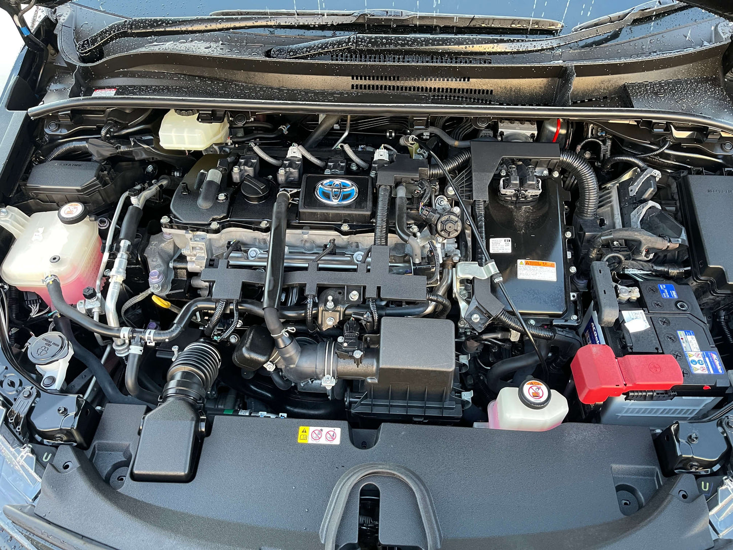 2019 Toyota Corolla Touring 1.8 Hybrid engine view under the hood, showcasing components and layout.